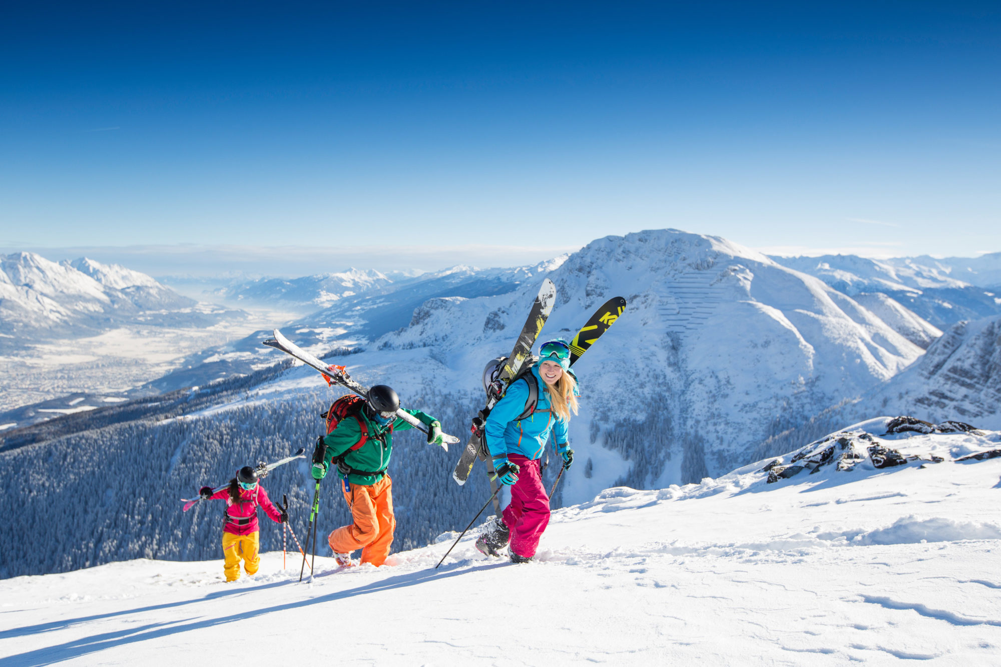 Kamaráti stúpajú hore lyžiarskym svahom v rakúskom Tirolsku.