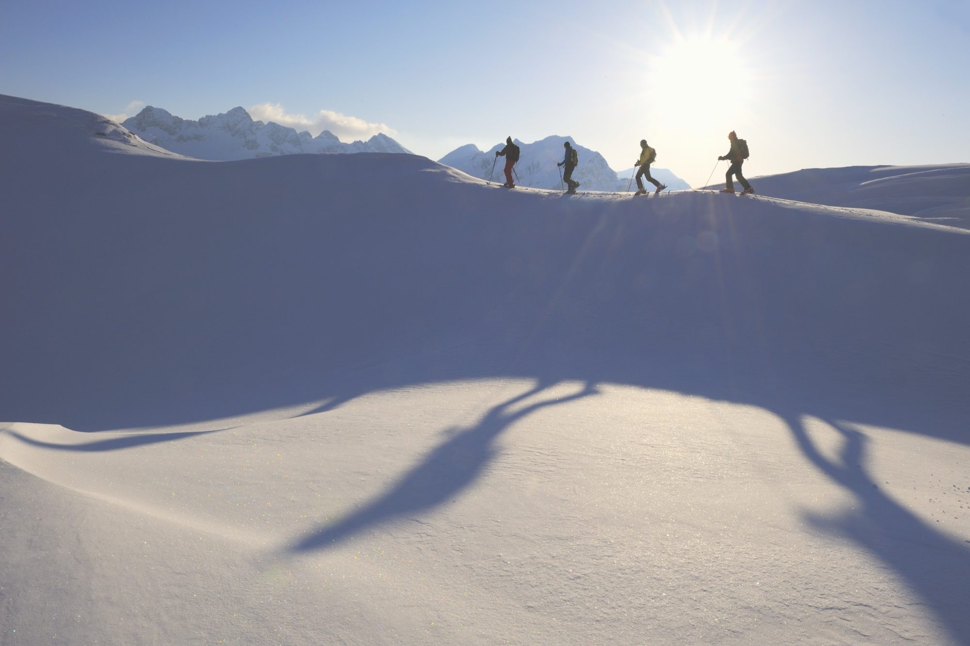 Skialpinisti stúpajú hore kopcom v rakúskom Vorarlbersku.